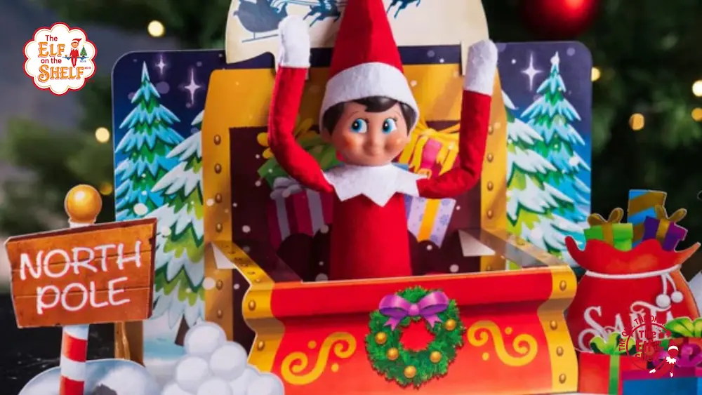 Elf on the Shelf scout elf popping out of a paper santa sleigh. with a North Pole sign.