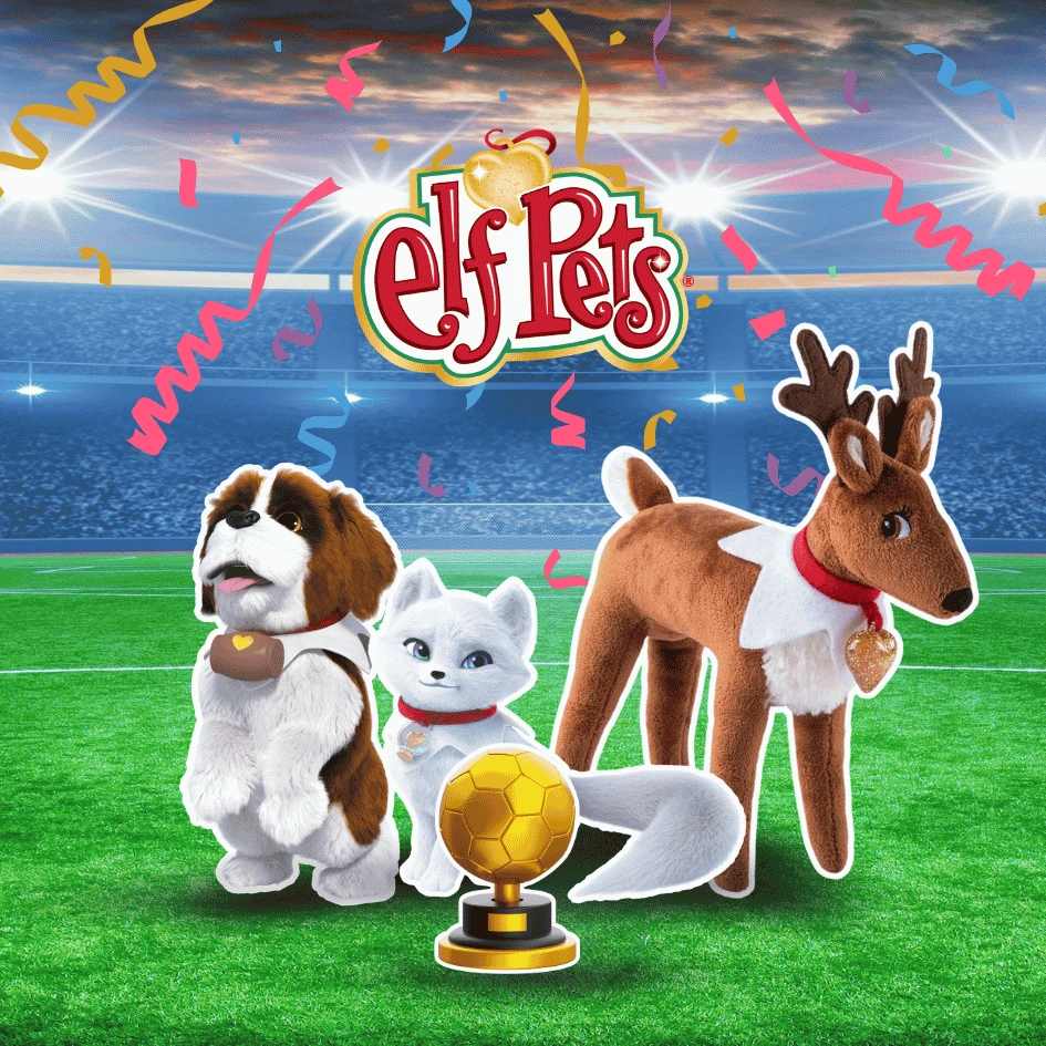 Elf Pets® Reno, Zorro Ártico y San Bernardo en un estadio de fútbol celebrando el trabajo en equipo, la bondad y el espíritu deportivo.