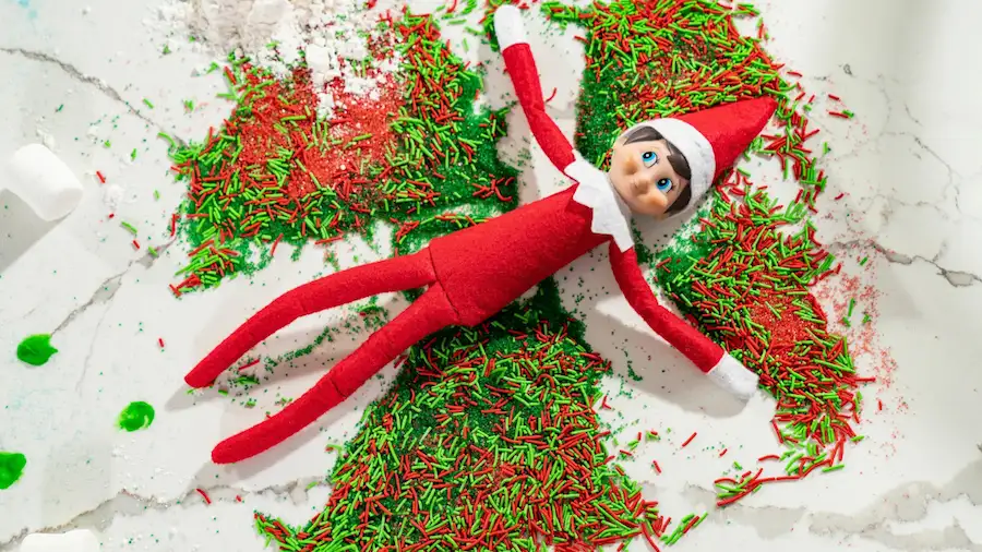 Scout elf making snow angels in red and green sprinkles