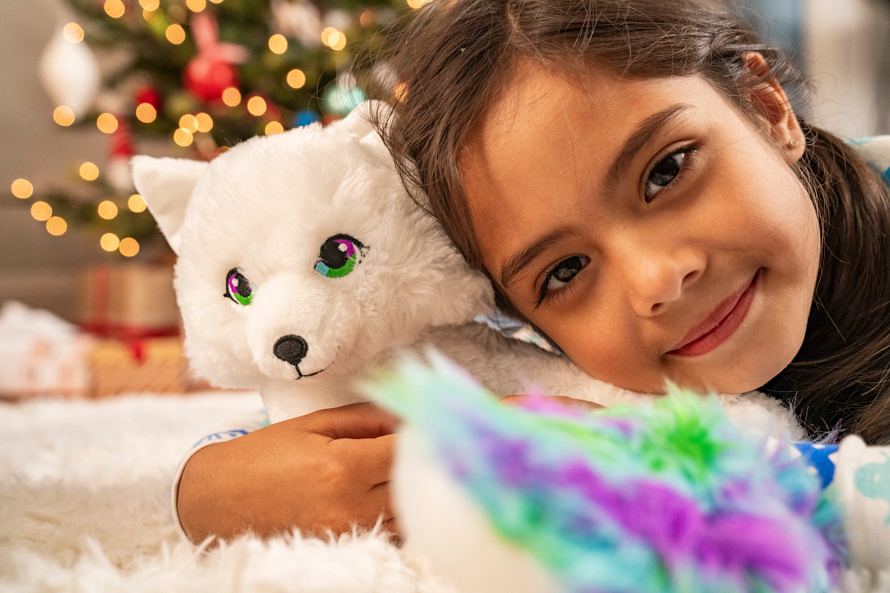 Noorah plush toy being held by young girl